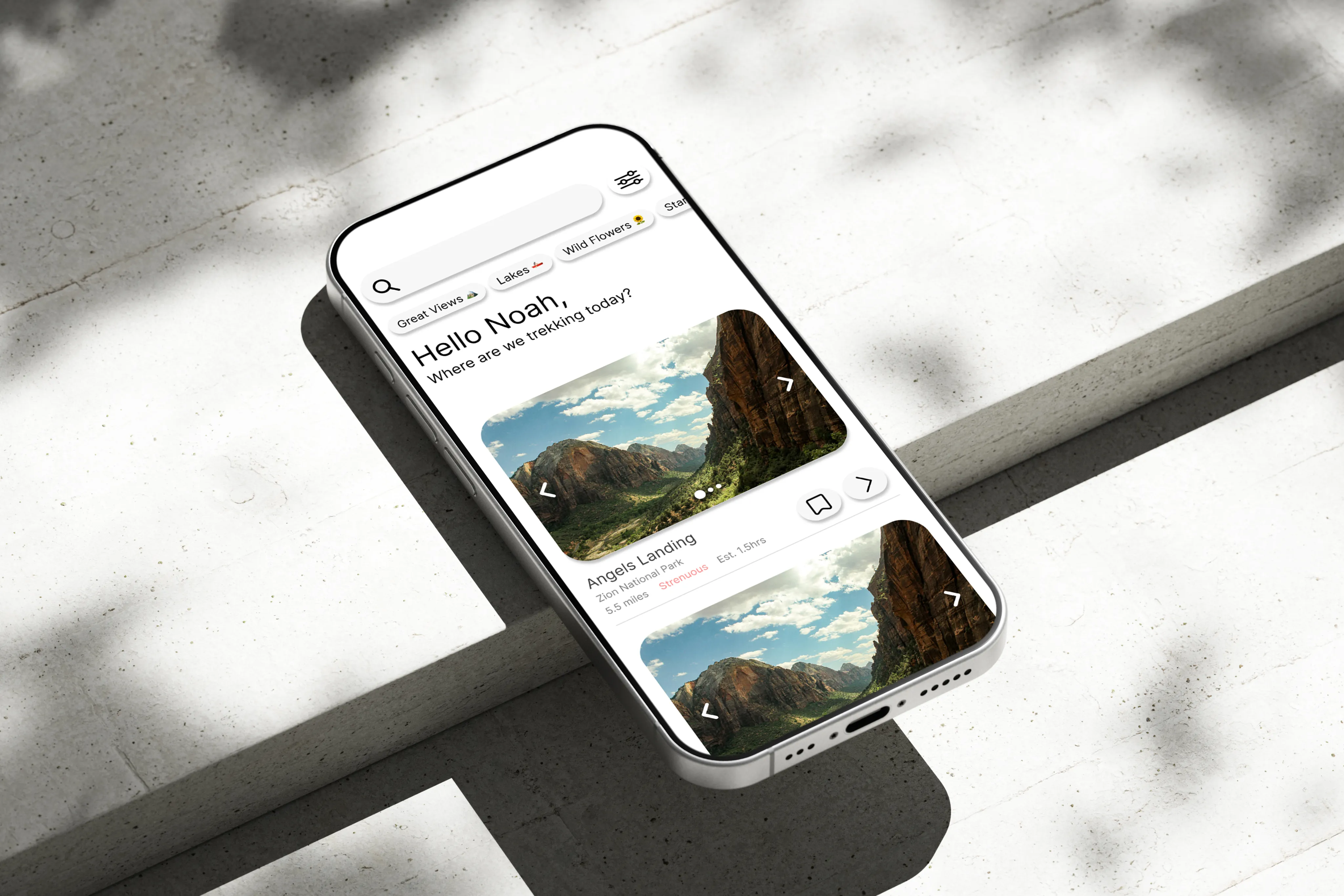 TREK app discover screen shown on a phone resting on concrete